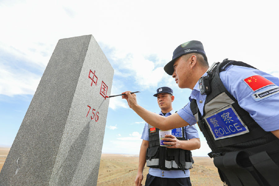 6.七一前夕,包头边境管理支队满都拉边境派出所与满都拉口岸边境派出所开展联合巡边踏查,图为民警为界碑描红。(张宇-3.jpg